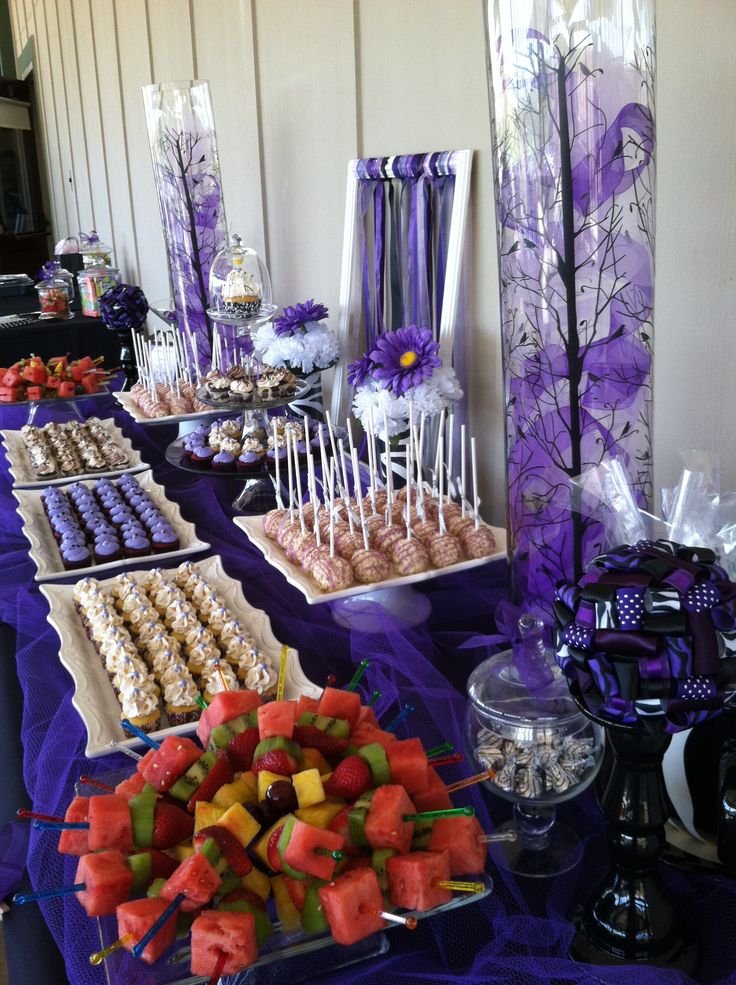 a table topped with lots of different types of desserts and candy bar items on top of purple cloth covered tables