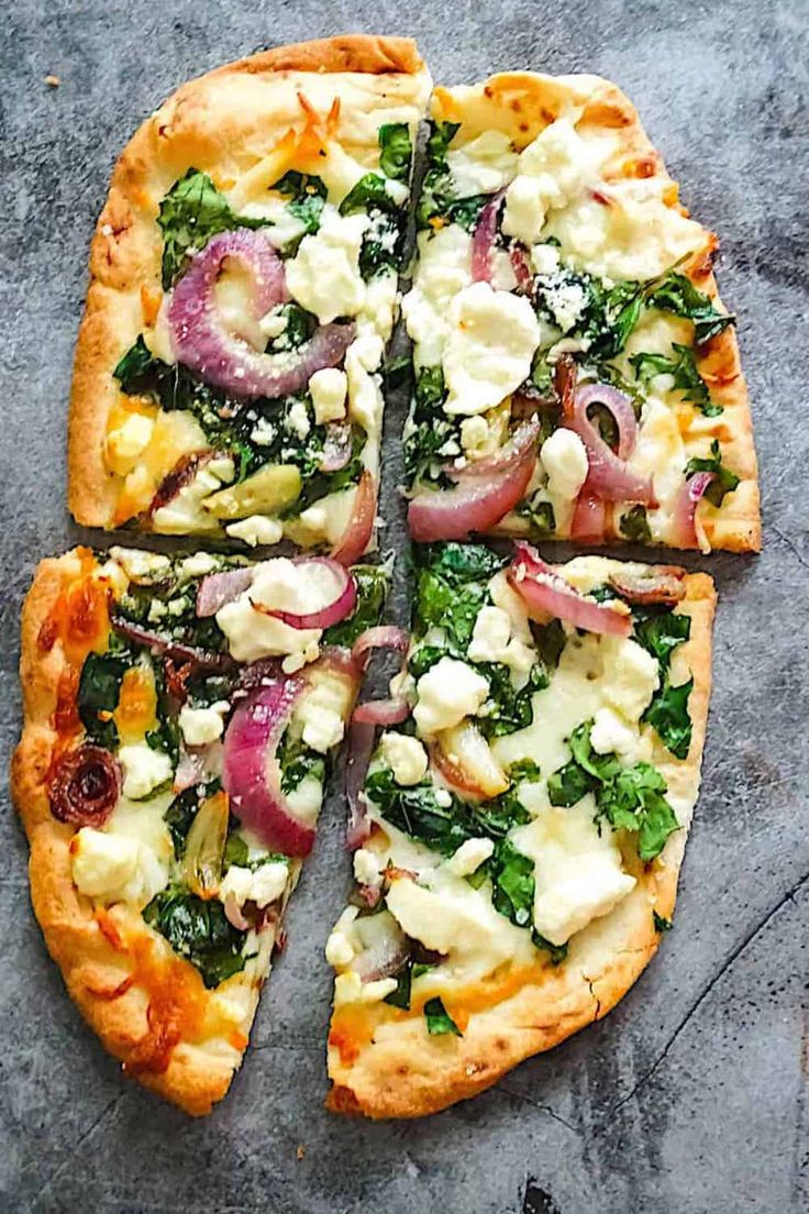 a pizza with many toppings cut into four pieces and sitting on top of a table