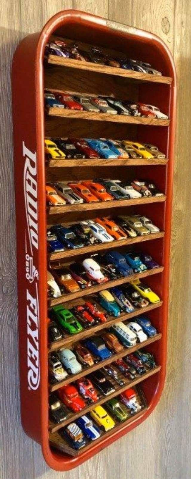 a red toy car storage rack on a wooden wall