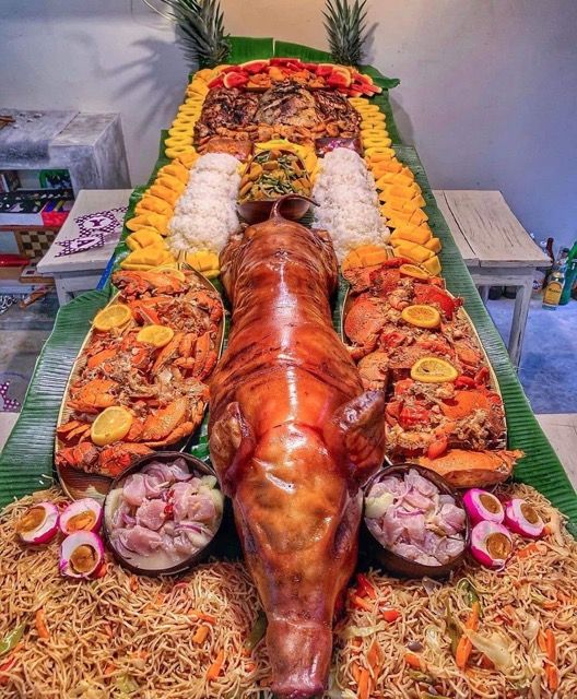 an elaborately decorated buffet with various foods on it's sides, including meats and vegetables