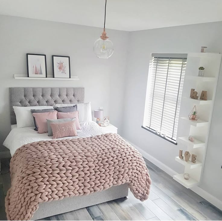 a bedroom with white walls and pink bedding