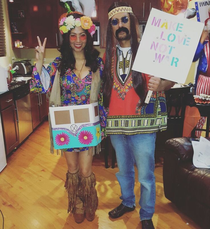 two people dressed up in costumes holding signs and posing for the camera while standing next to each other