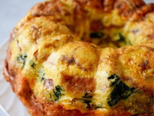 a close up of a bundt cake on a plate with broccoli and cheese