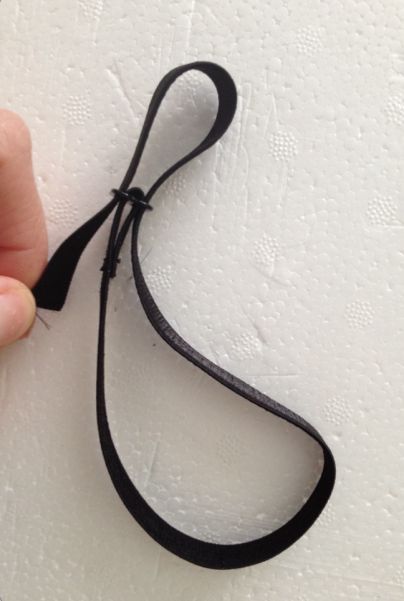 a person is holding a black string on a white surface