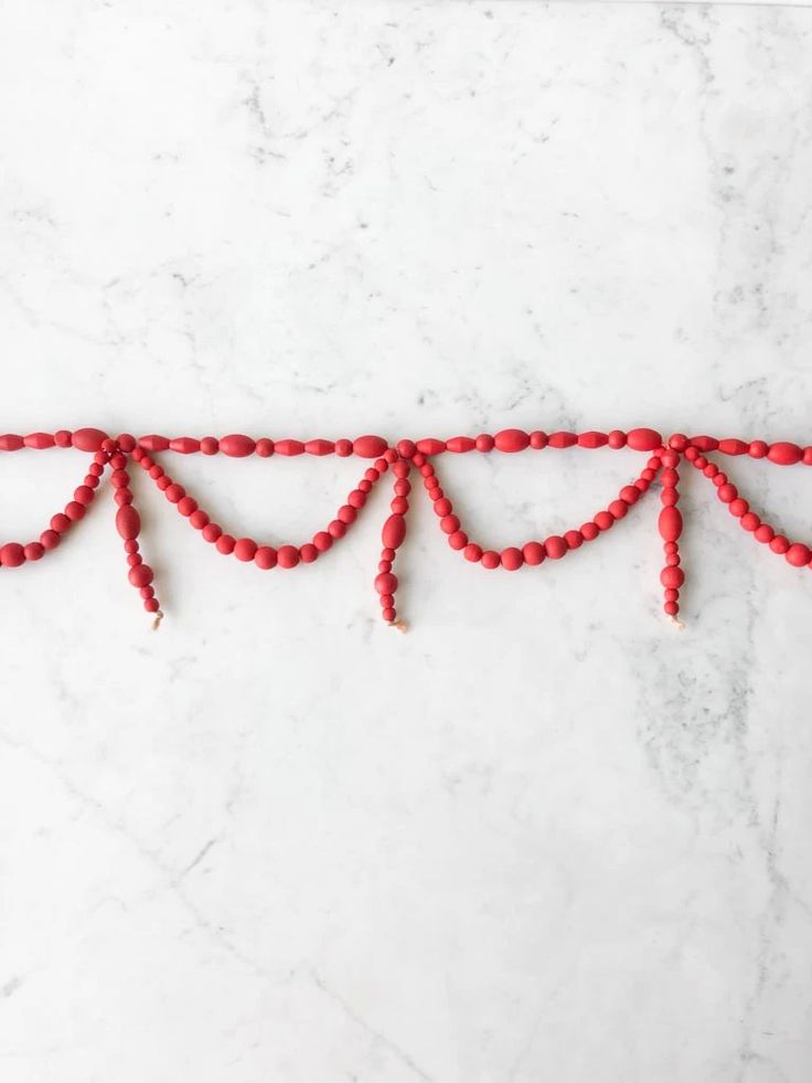 red beaded garland on white marble background