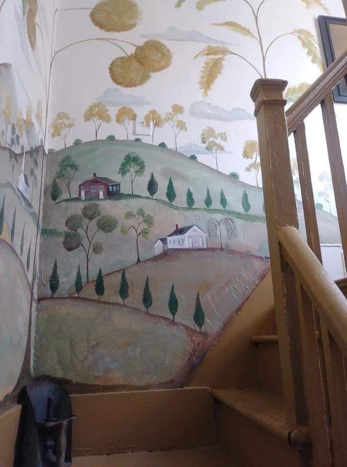 the stairs are painted with trees and hills on them, along with a painting of a farm