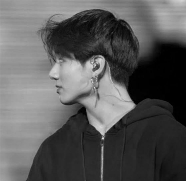 black and white photograph of a person with ear piercings