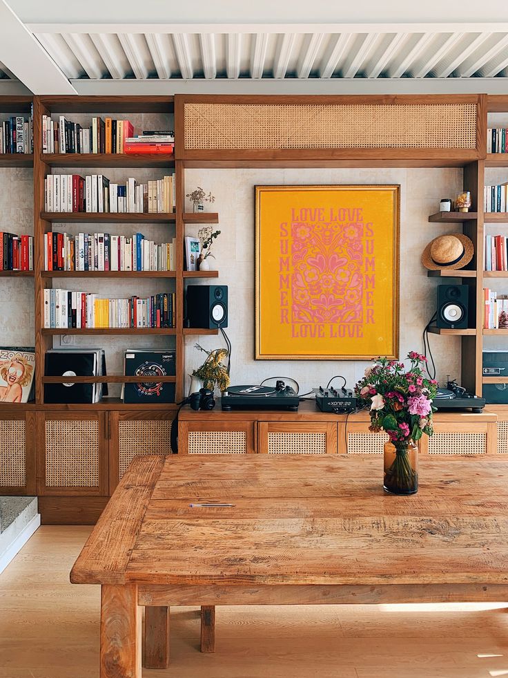 a wooden table sitting in front of a book shelf filled with books