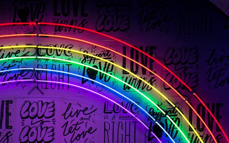 a rainbow lit up in the dark with writing all over it