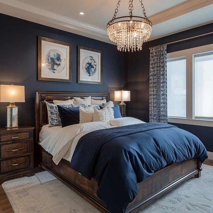 a bedroom with blue and white bedding, chandelier and pictures on the wall