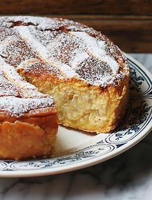 a cake with powdered sugar on top sits on a plate