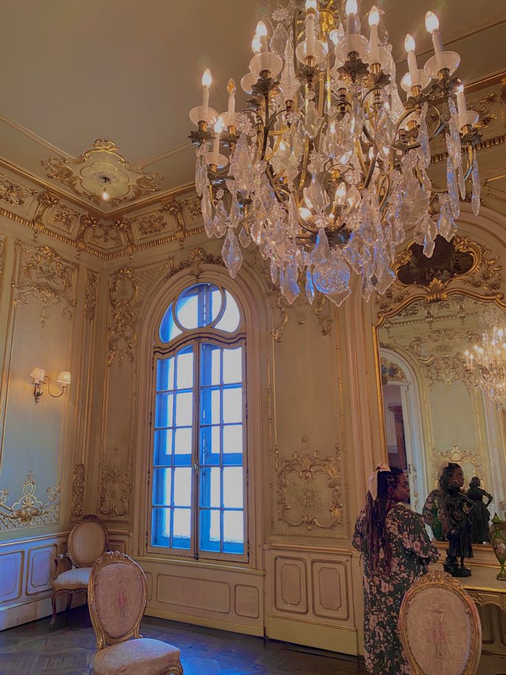 a chandelier hangs from the ceiling in an ornate room