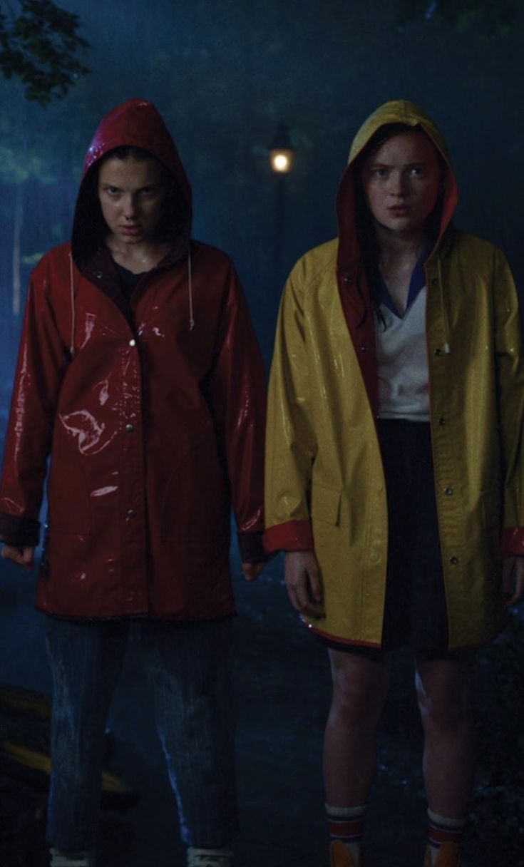 two people in raincoats standing next to each other