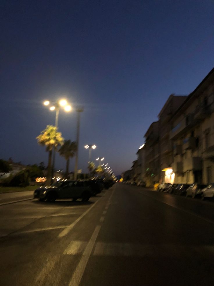 cars are parked on the street at night