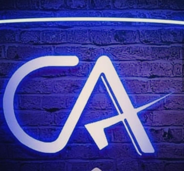 an illuminated sign for a car dealership with the letter ca in white on a brick wall