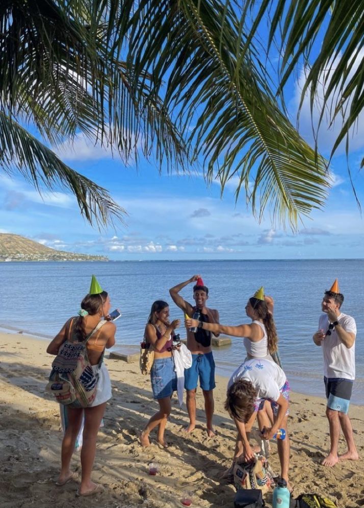 group of people standing on the beach near water