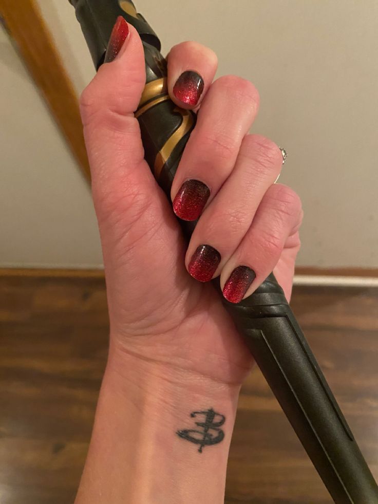 a woman's hand holding an umbrella with a tattoo on it