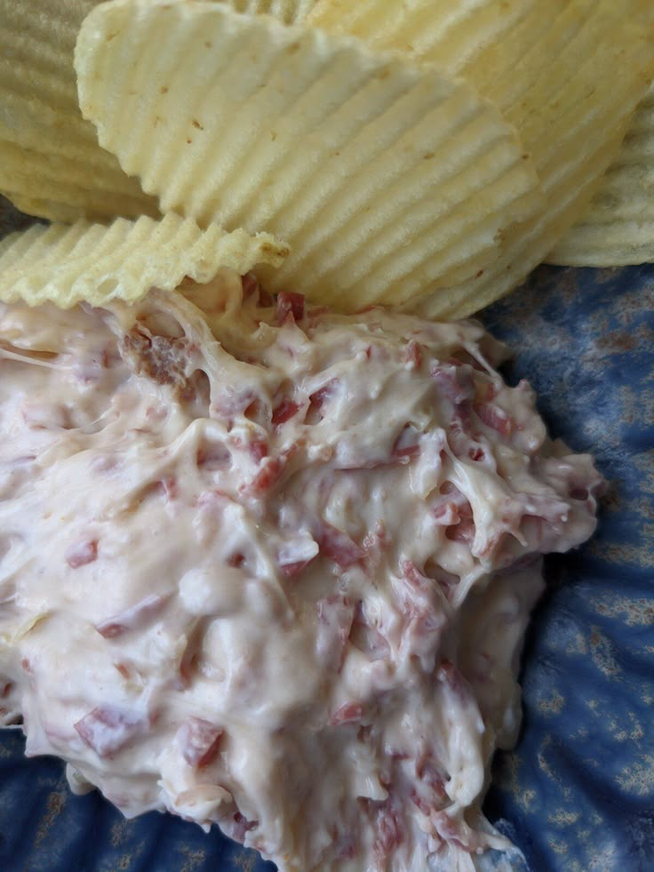 a blue plate topped with potato chips and dip