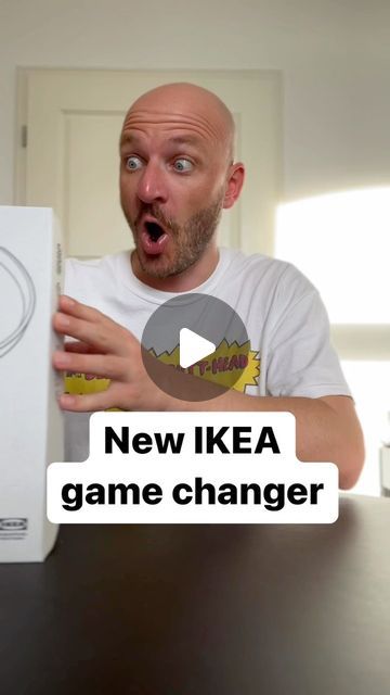 a man holding a wii game controller in front of his face with the words new ikea game changer on it