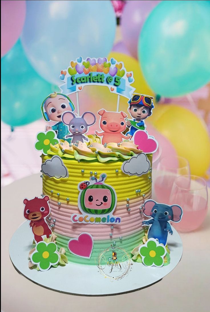 a birthday cake decorated with cartoon characters and balloons