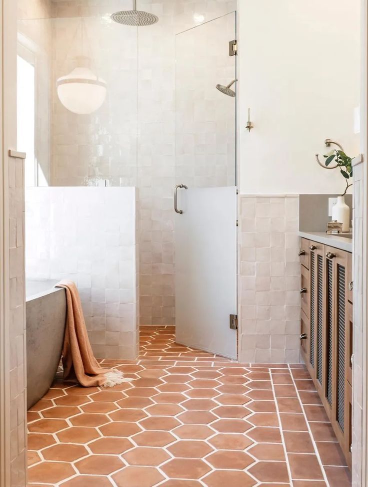 a bathroom with a walk in shower sitting next to a sink and a bath tub