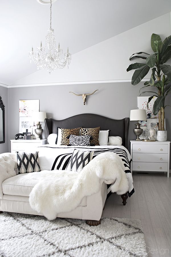 a white and black bedroom with lots of pillows