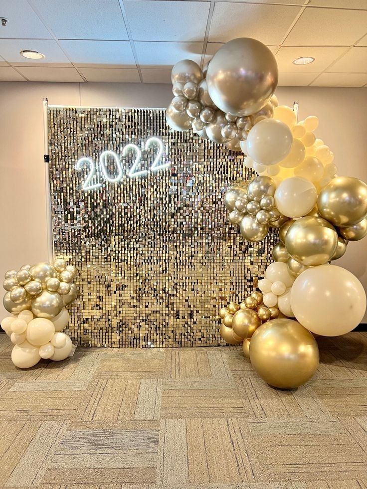 an office decorated with gold and white balloons