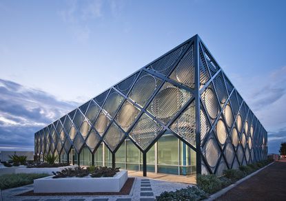 a glass building that is sitting on the side of a road