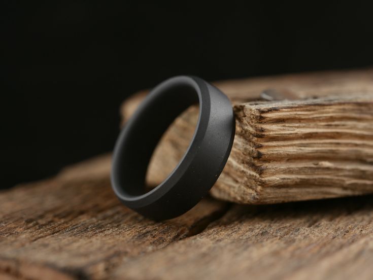 a black ring sitting on top of a piece of wood