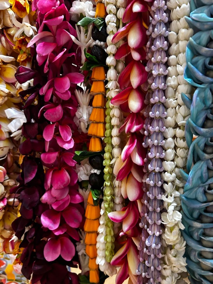 many different colored flowers are hanging on the wall