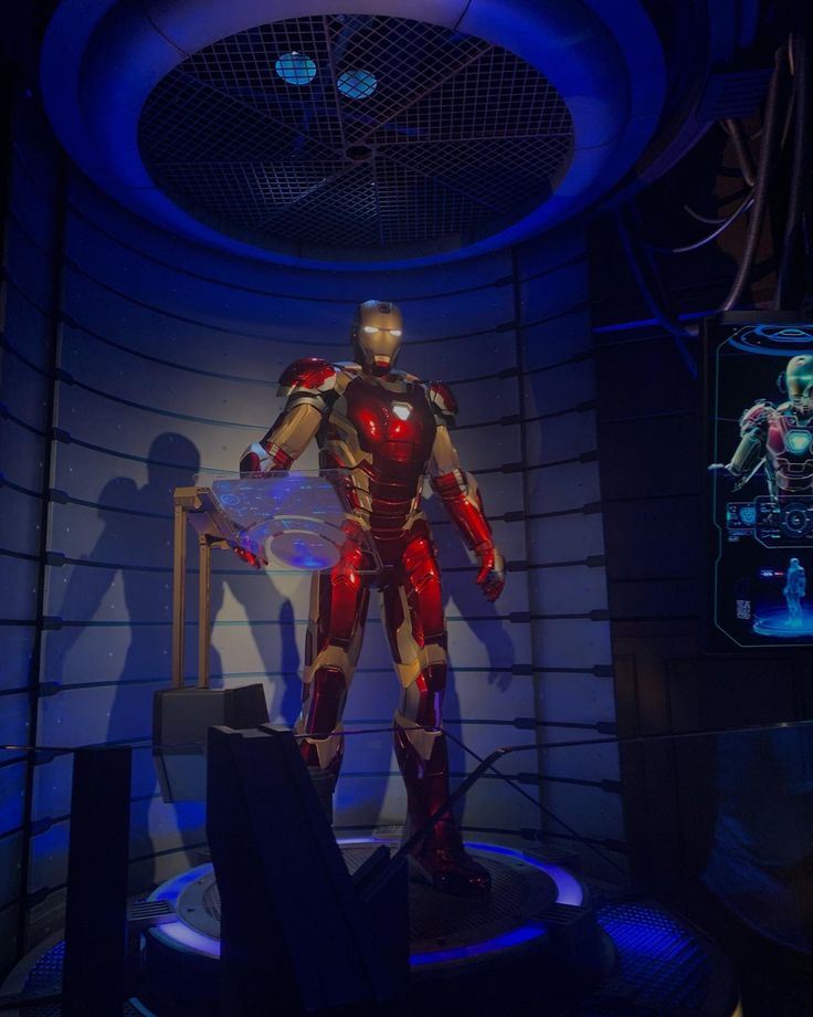 the iron man suit is on display in front of a blue wall and round ceiling