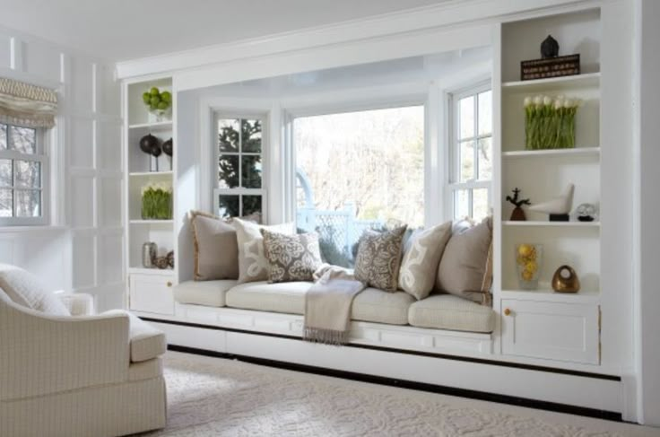 a living room filled with lots of white furniture