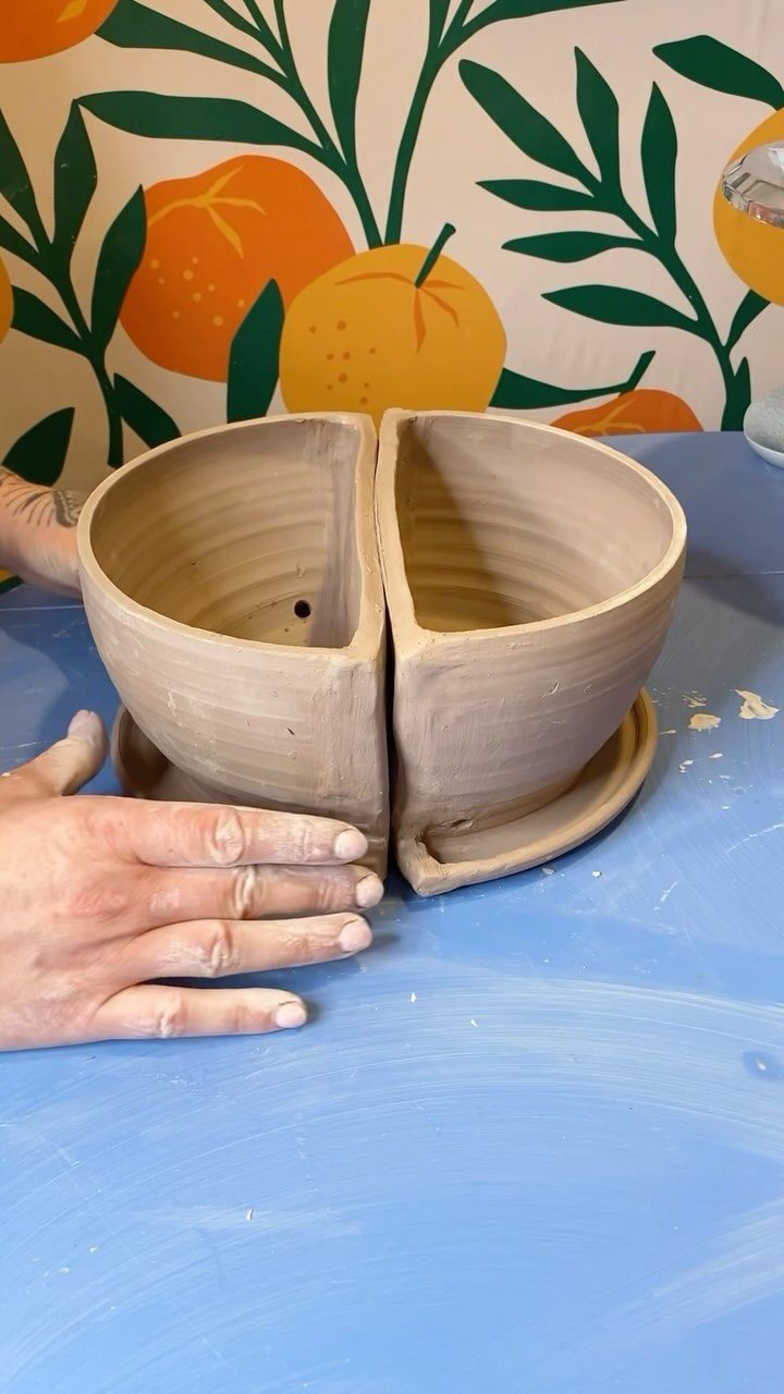 a person is making a bowl out of wood and clay with their hands on the table