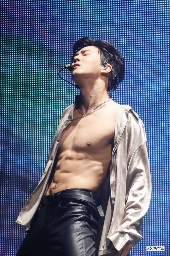 a shirtless man is performing on stage