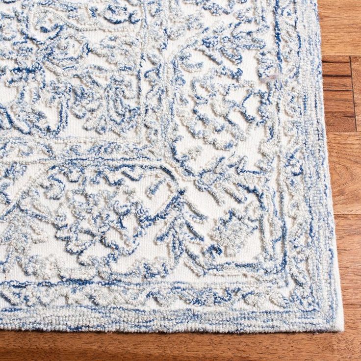 a blue and white area rug on a wooden floor with a wood floor in the background