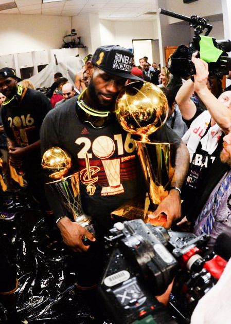 a group of people standing around each other with trophies in their hands and one person holding a trophy