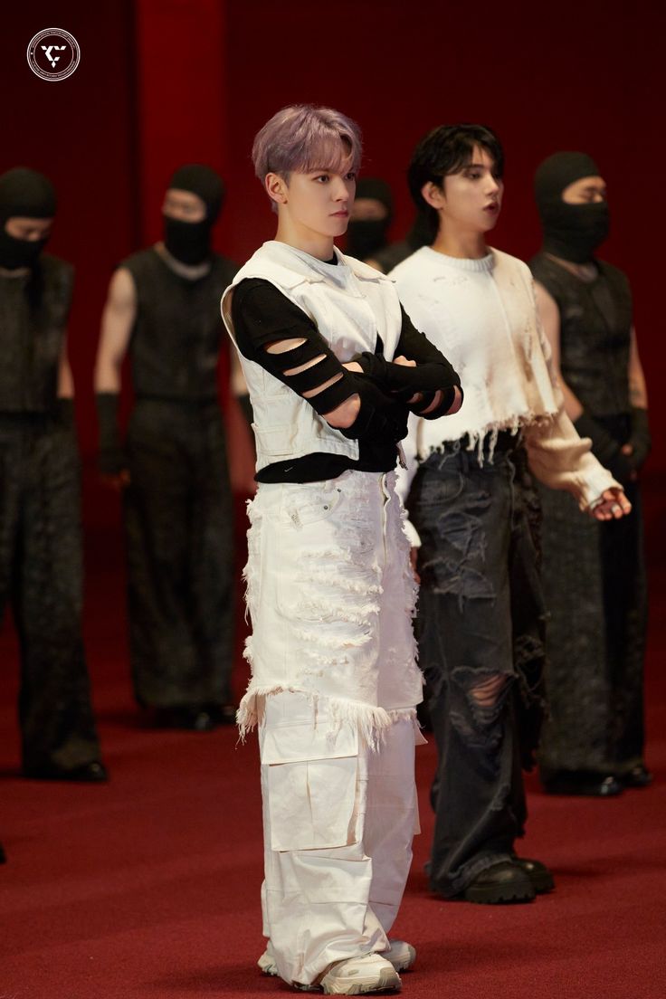 two men in costumes standing next to each other on a red carpeted area with black and white outfits