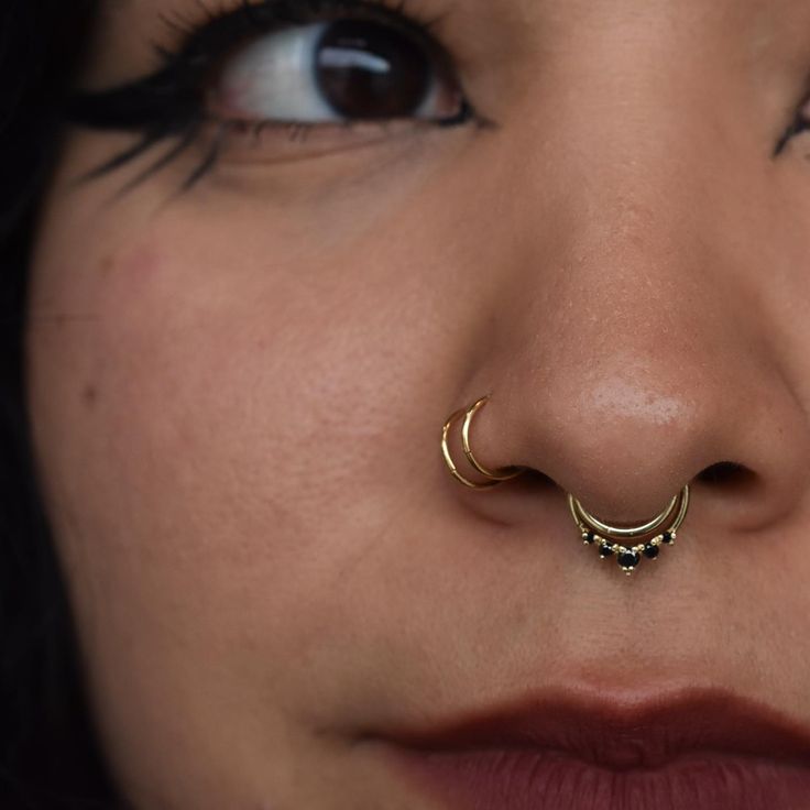 a woman's nose has a gold nose ring on it