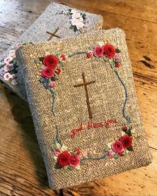 two small cross book covers with flowers on them