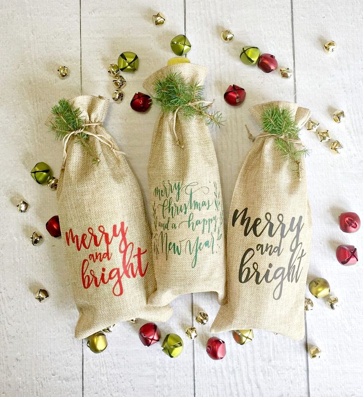 two bags with christmas sayings on them sitting next to some candy canes and bells