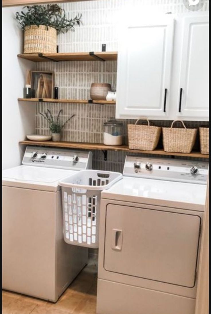 a washer and dryer in a small laundry room with open shelving on the wall