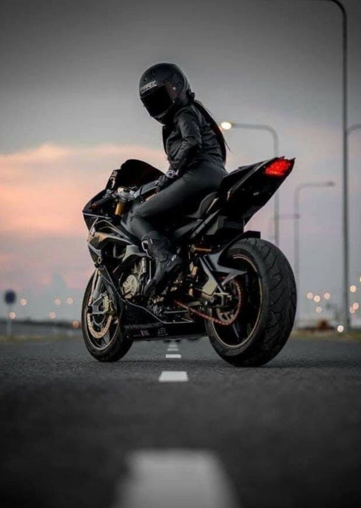 a man riding on the back of a black motorcycle