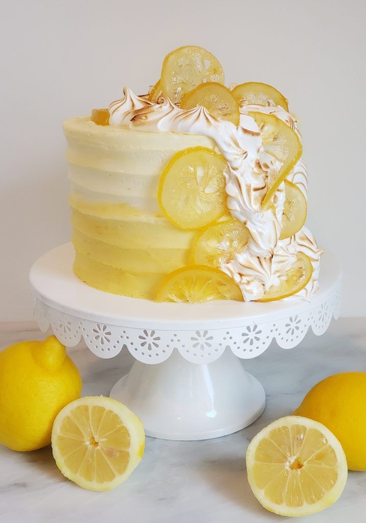 there is a cake with lemons on the top and two lemons around it