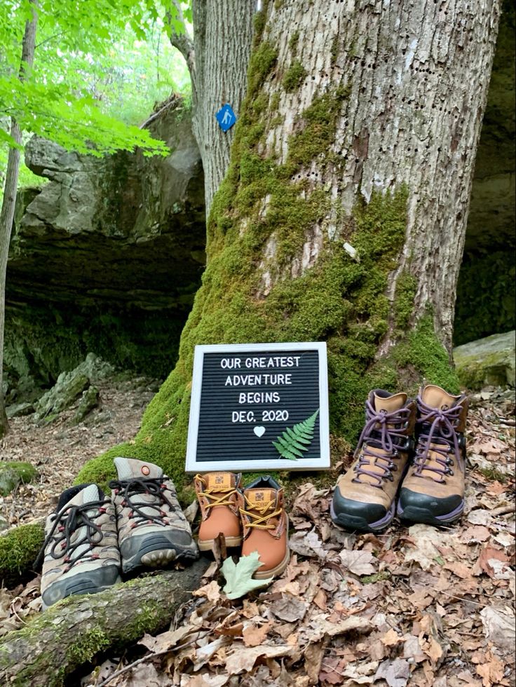 two hiking boots are sitting next to a sign