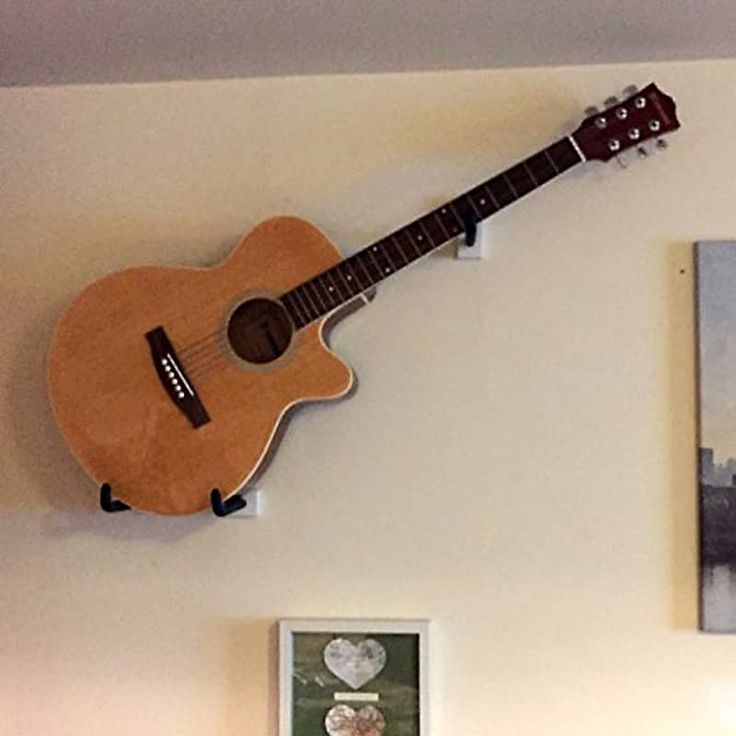 a guitar mounted to the wall above a bed