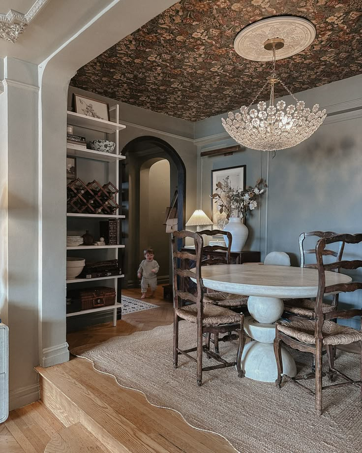 a dining room with a chandelier hanging from the ceiling