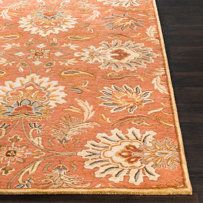 an orange rug with floral designs on it