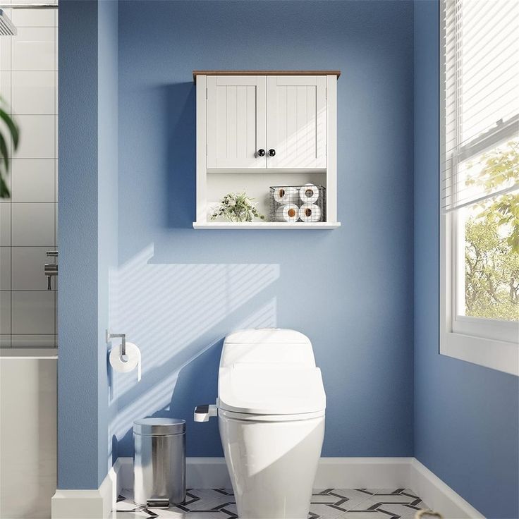 a white toilet sitting in a bathroom next to a window