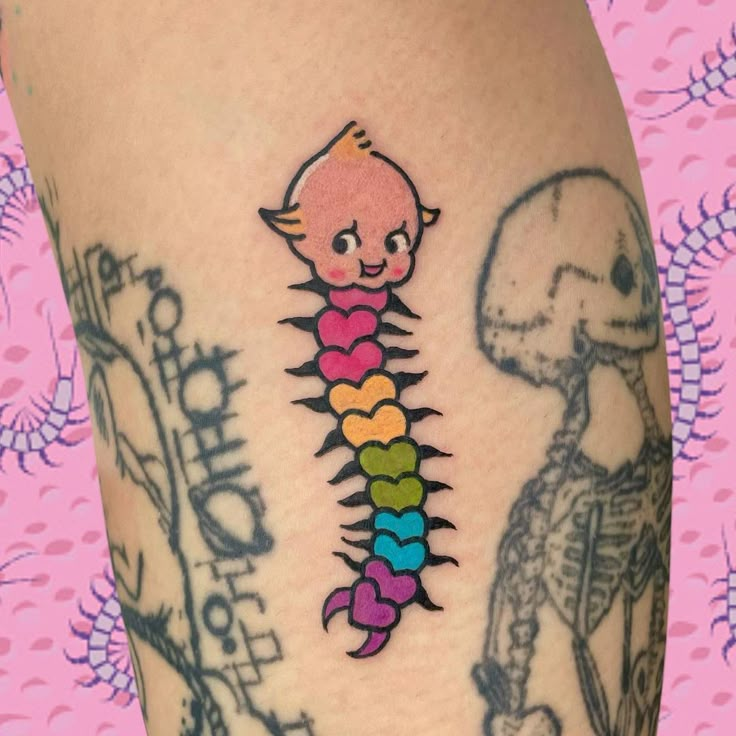 a colorful tattoo on the leg of a person with a skeleton and rainbows in it