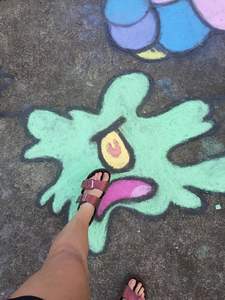 someone is standing on the sidewalk with their feet in front of chalk art that looks like an octopus